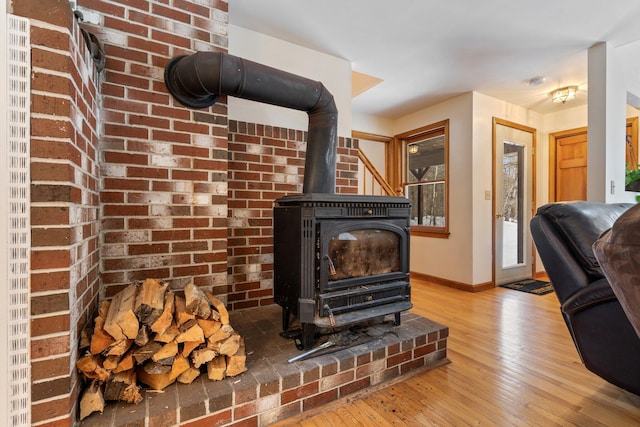 room details with a wood stove, baseboards, and wood finished floors