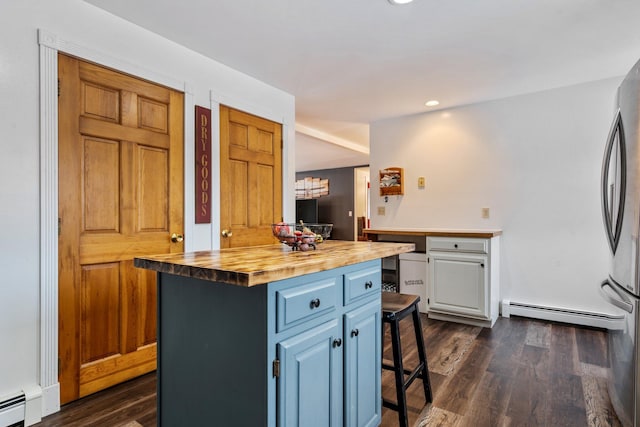 kitchen featuring a breakfast bar area, dark wood-style floors, freestanding refrigerator, wood counters, and a baseboard heating unit