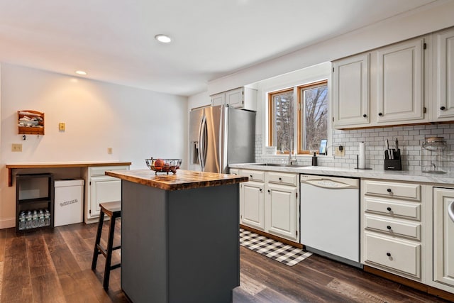 kitchen featuring dark wood finished floors, stainless steel fridge with ice dispenser, white dishwasher, a sink, and butcher block countertops