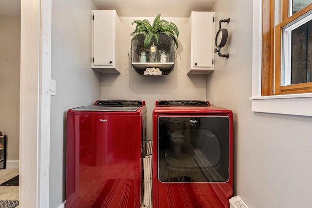 clothes washing area featuring cabinet space and independent washer and dryer