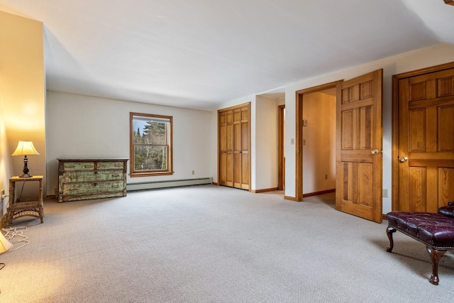 living area with light carpet, baseboard heating, and baseboards