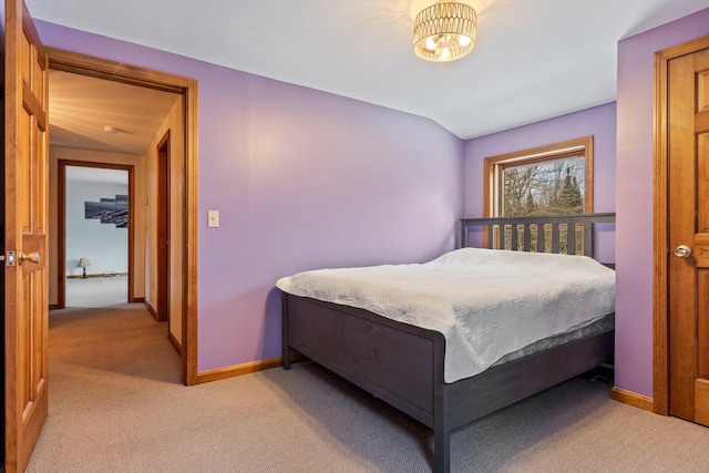 bedroom with light carpet, lofted ceiling, and baseboards