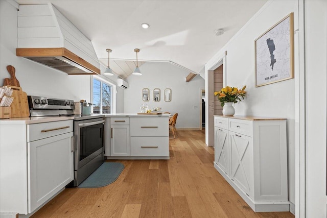 kitchen with light wood finished floors, premium range hood, lofted ceiling, stainless steel range with electric cooktop, and a wall mounted AC