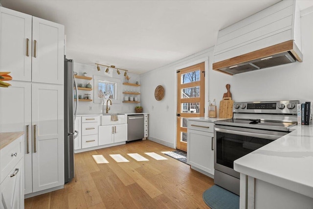 kitchen featuring a sink, light countertops, light wood-style floors, and stainless steel appliances