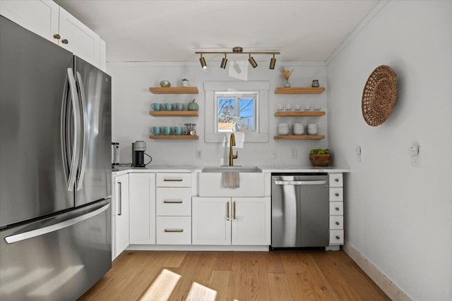 kitchen with light countertops, stainless steel appliances, light wood-style floors, white cabinetry, and open shelves