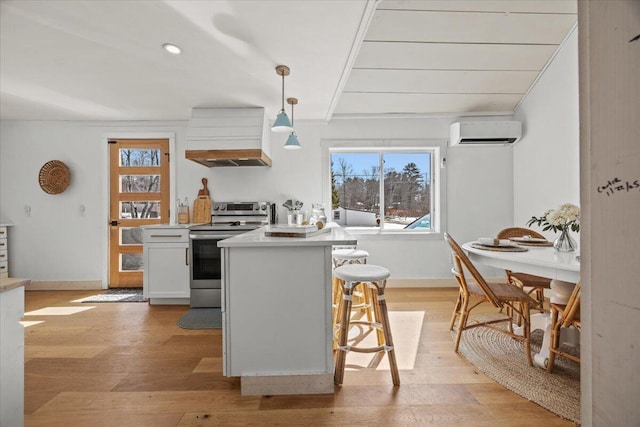 kitchen featuring a wall mounted air conditioner, light wood-style flooring, stainless steel electric range oven, and plenty of natural light