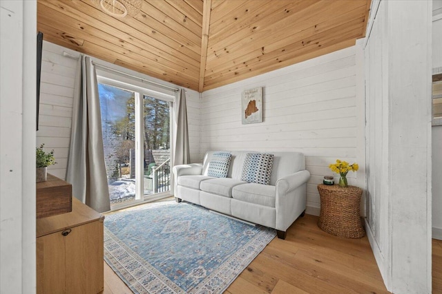 living area with wooden walls, wood ceiling, and light wood finished floors