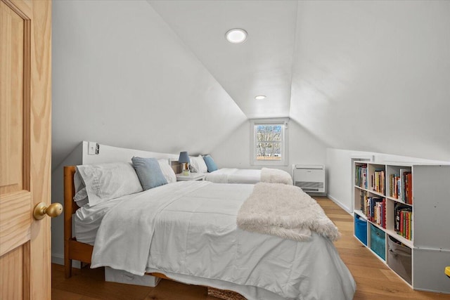 bedroom with vaulted ceiling, recessed lighting, and wood finished floors