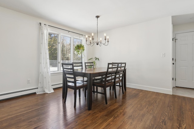 dining room featuring a chandelier, baseboard heating, baseboards, and wood finished floors