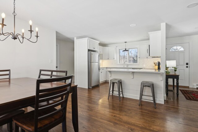 dining area featuring an inviting chandelier and dark wood-style flooring