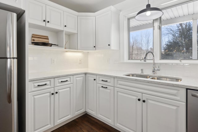 kitchen featuring a sink, dark wood finished floors, appliances with stainless steel finishes, white cabinets, and decorative backsplash