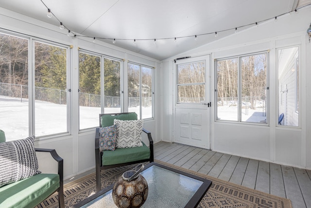 sunroom with track lighting, a healthy amount of sunlight, and vaulted ceiling