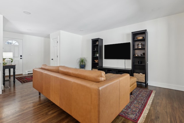 living area featuring a baseboard heating unit, baseboards, and dark wood-style floors