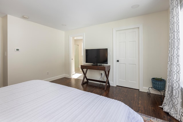 bedroom with baseboards and dark wood finished floors