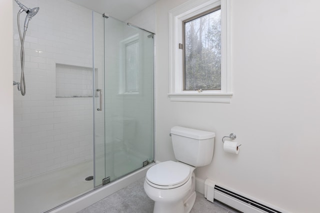 bathroom with a baseboard heating unit, a shower stall, toilet, and baseboards