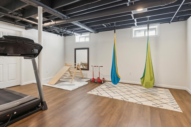 workout area featuring wood finished floors and baseboards