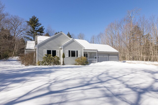 view of front of home featuring covered porch, an attached garage, and a chimney