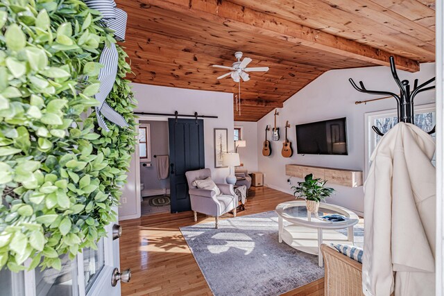 living area with light wood finished floors, lofted ceiling, ceiling fan, wood ceiling, and a barn door