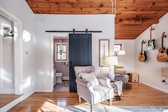 sitting room with lofted ceiling, a barn door, wood finished floors, and wooden ceiling