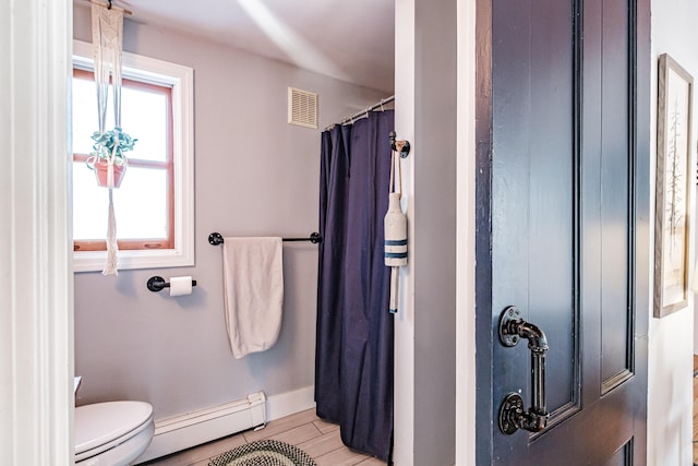 full bath featuring wood finished floors, baseboards, visible vents, a baseboard radiator, and toilet