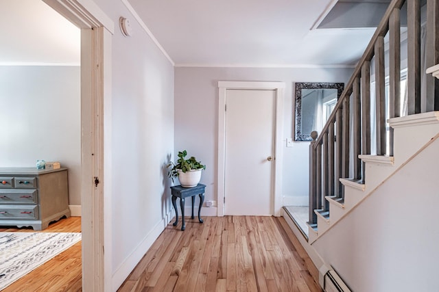 entrance foyer featuring baseboards, light wood-style flooring, stairs, and ornamental molding