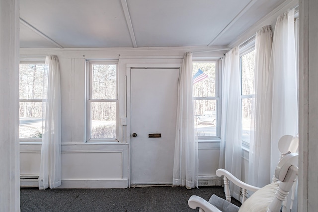 interior space with a baseboard heating unit and dark carpet