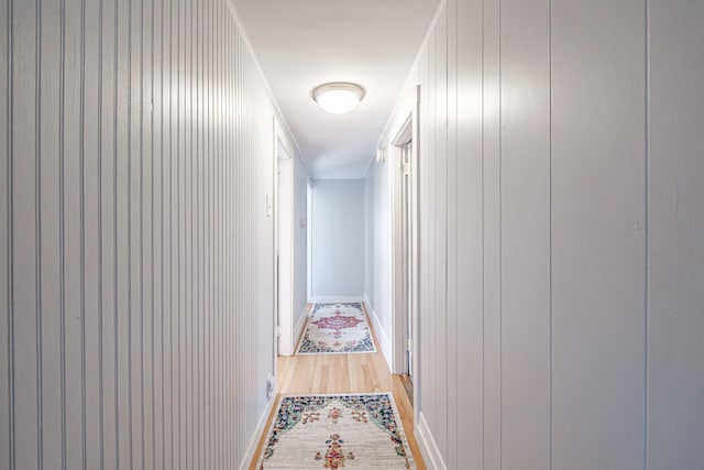 corridor featuring baseboards and light wood-style floors