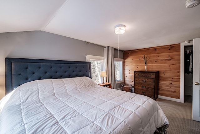 carpeted bedroom with baseboards, lofted ceiling, and wood walls