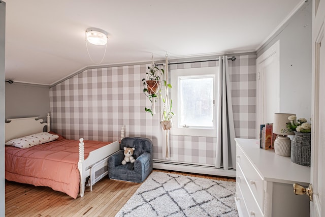 bedroom featuring wallpapered walls, vaulted ceiling, light wood-style floors, crown molding, and baseboard heating