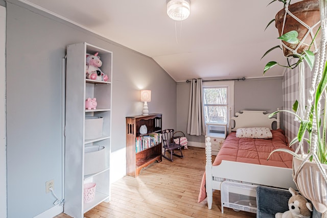 bedroom with lofted ceiling and light wood-style flooring