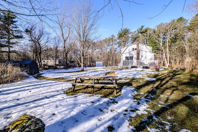 snowy yard featuring a wooden deck