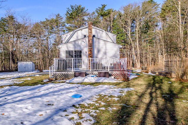 exterior space featuring an outbuilding, a shed, a gambrel roof, and a deck