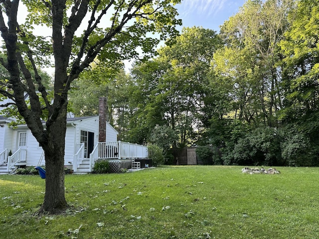 view of yard with entry steps, fence, and a wooden deck