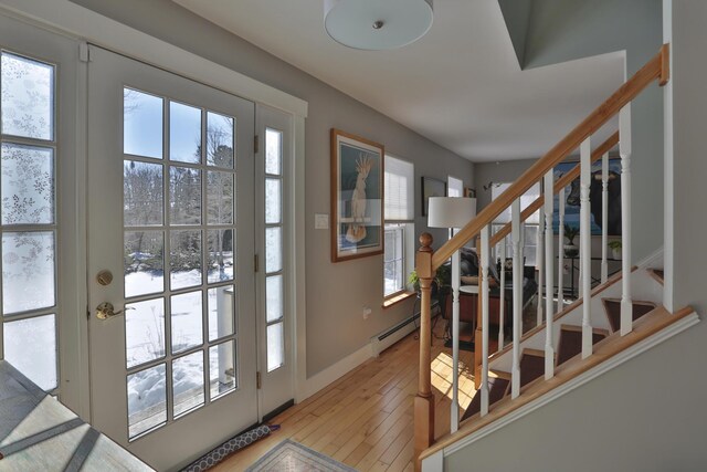 doorway to outside featuring baseboards, stairway, a baseboard radiator, and light wood-type flooring
