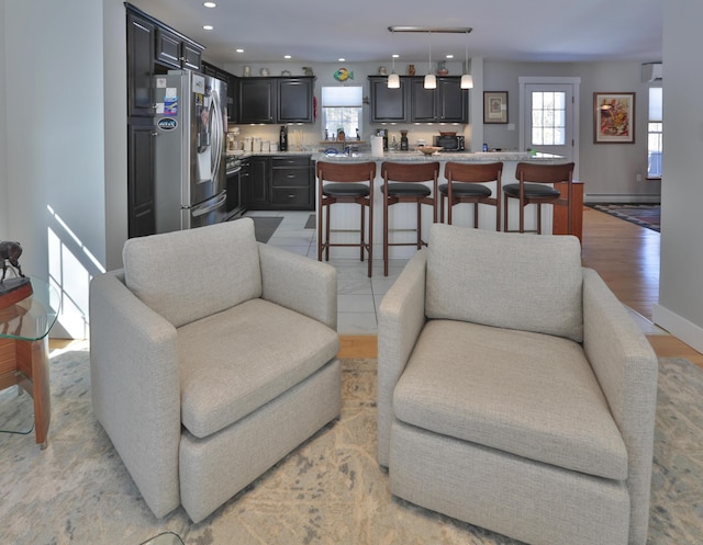 living room with baseboards, light wood-type flooring, and recessed lighting
