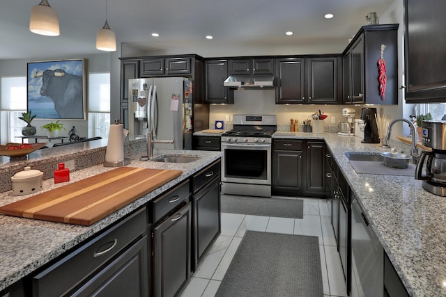 kitchen featuring under cabinet range hood, stainless steel appliances, a sink, and light stone counters