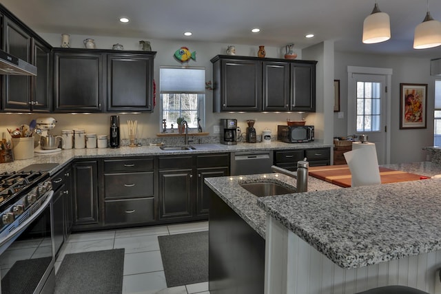 kitchen featuring stainless steel gas stove, light stone counters, dishwashing machine, black microwave, and plenty of natural light