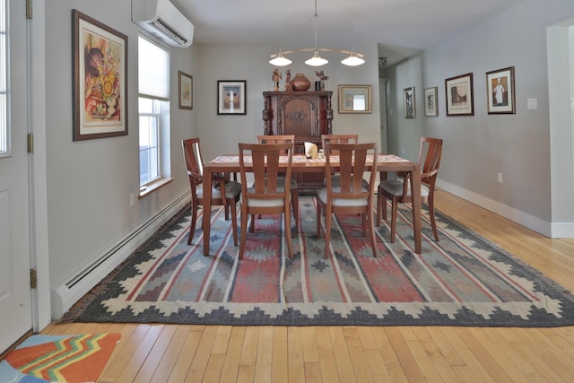 dining area featuring a wall mounted air conditioner, baseboards, hardwood / wood-style floors, and a baseboard heating unit