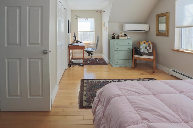 bedroom featuring light wood finished floors, a wall mounted air conditioner, multiple windows, and baseboards