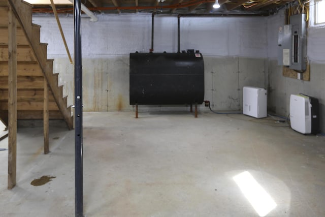 unfinished below grade area with electric panel, heating fuel, and stairway