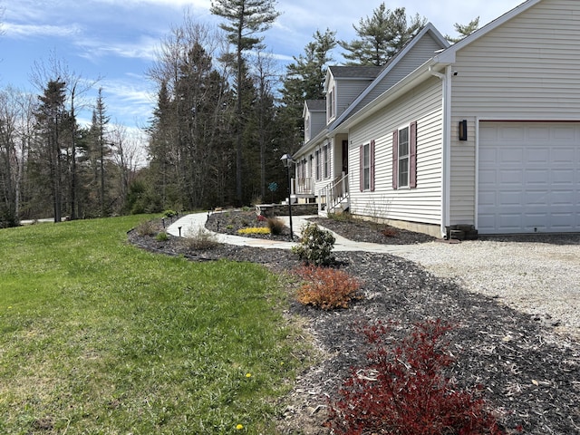 view of side of home featuring a garage and a lawn