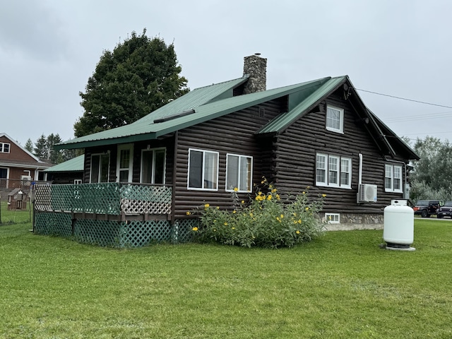 back of property featuring a yard, metal roof, and a chimney