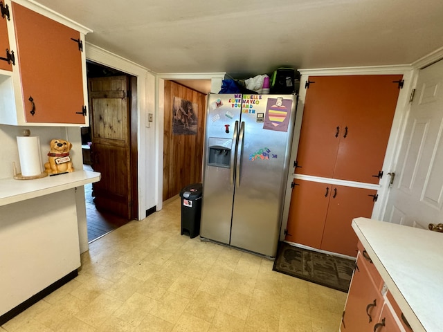 kitchen featuring light countertops, light floors, stainless steel refrigerator with ice dispenser, and baseboards