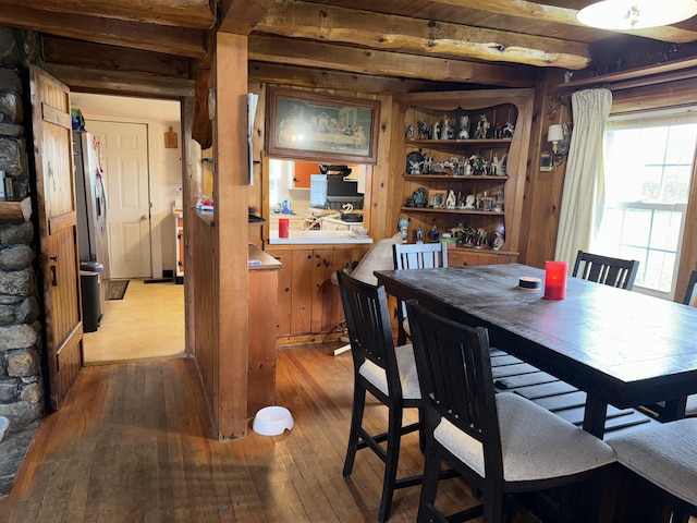 dining space featuring hardwood / wood-style flooring and beam ceiling