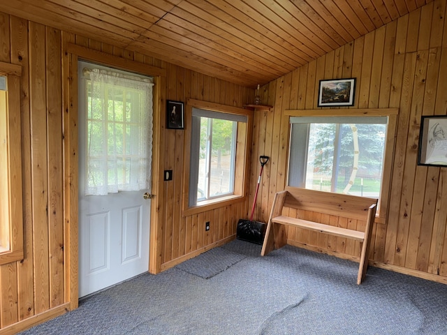 entryway with lofted ceiling, wood ceiling, wood walls, and carpet floors