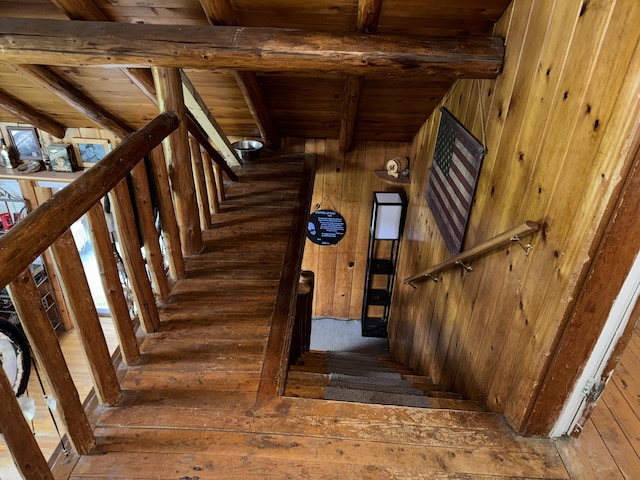 staircase with hardwood / wood-style flooring, beamed ceiling, wood ceiling, and wood walls