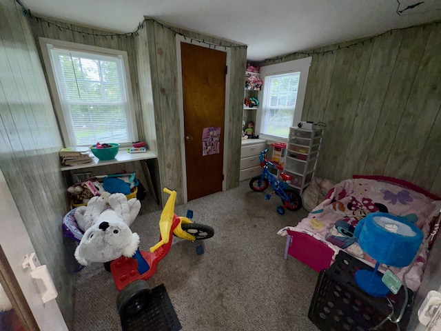 carpeted bedroom with wood walls