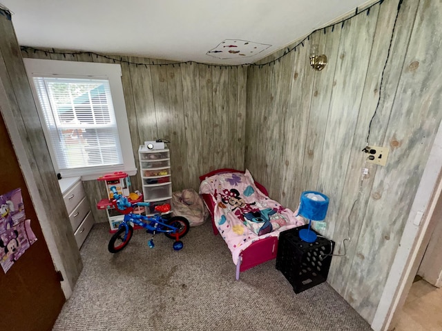 bedroom with carpet floors and wooden walls