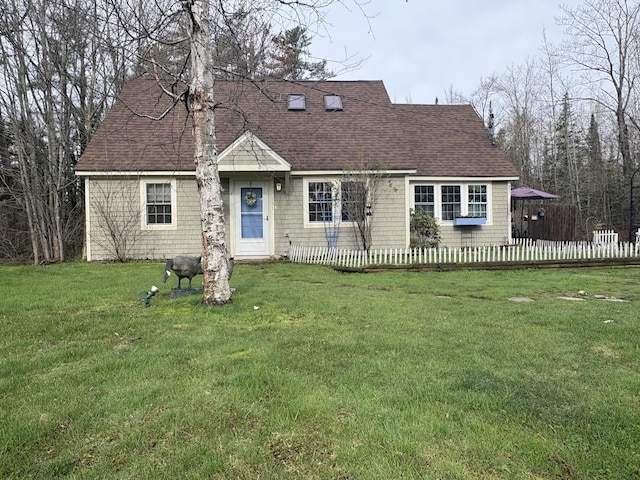cape cod house featuring a front yard, a shingled roof, and fence