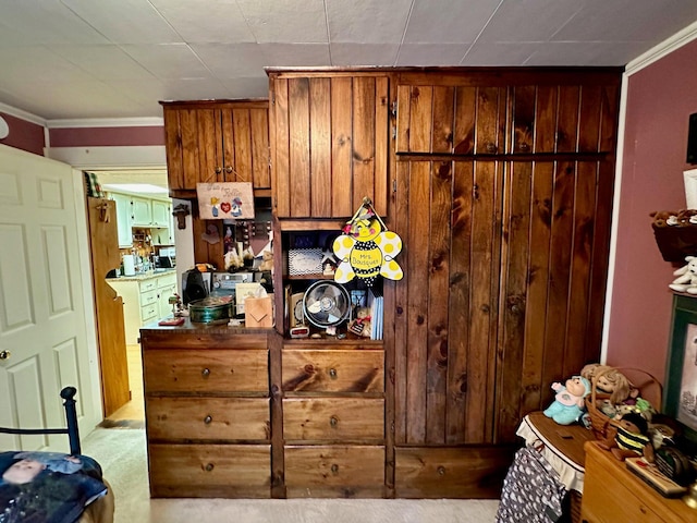 kitchen with brown cabinets, carpet floors, and ornamental molding